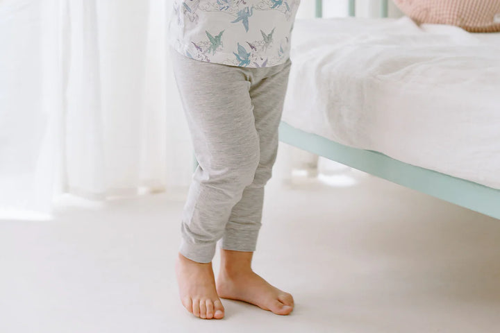 Lifestyle image showing the grey pants that coordiante with the Kids Two-Piece Pajama Set  - Cloud Ponies