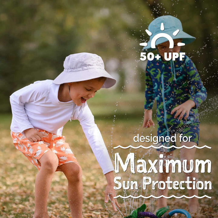 Graphic that says - designed for maximum sun protection and features child wearing the sunshorts, rash guard, and hat while playing in the sprinkelr