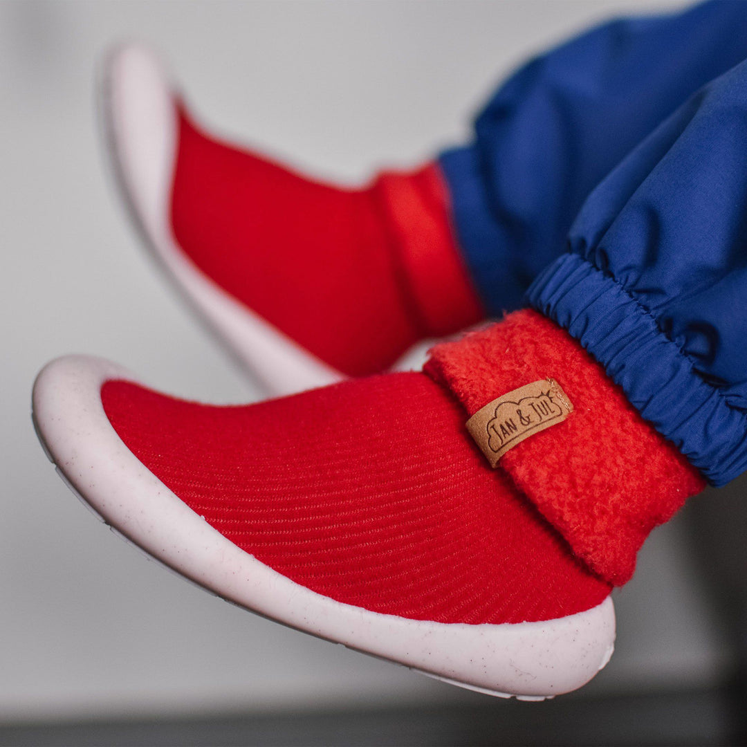 Lifestyle photo of a child wearing the red Product photo of the Cozy Sock Shoe | Jan & Jul in rose
