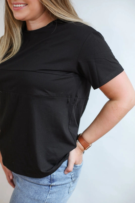 Woman wearing a Movemama Full Zip Breastfeeding Tee in Black showing the hidden zipper for discrete access