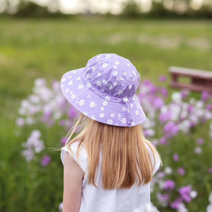 Child wearing Jan & Jul Cotton Bucket Hat in purple daisy, view of the back of her head