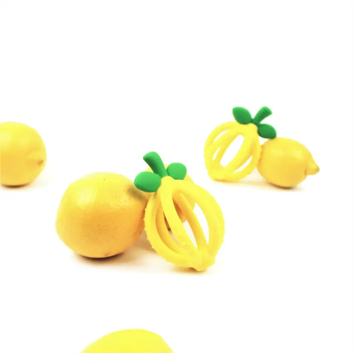 The yellow Bitzy Biter™ Teething Ball & Training Toothbrush with lemons in a display