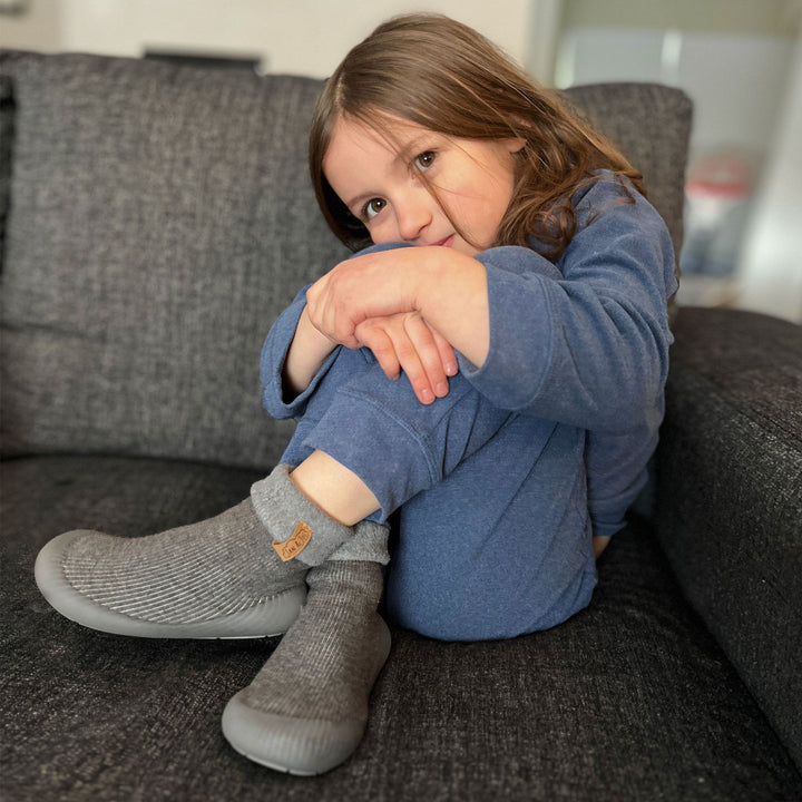 Lifestyle photo of a kid wearing the Cozy Sock Shoe | Jan & Jul in grey