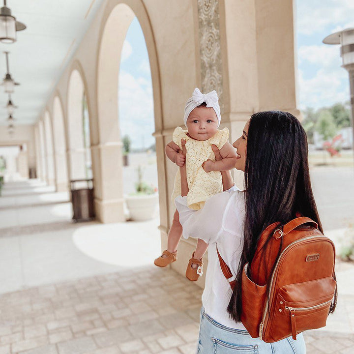 Lifestyle image of the Itzy Mini™ Diaper Bag Backpack | Cognac