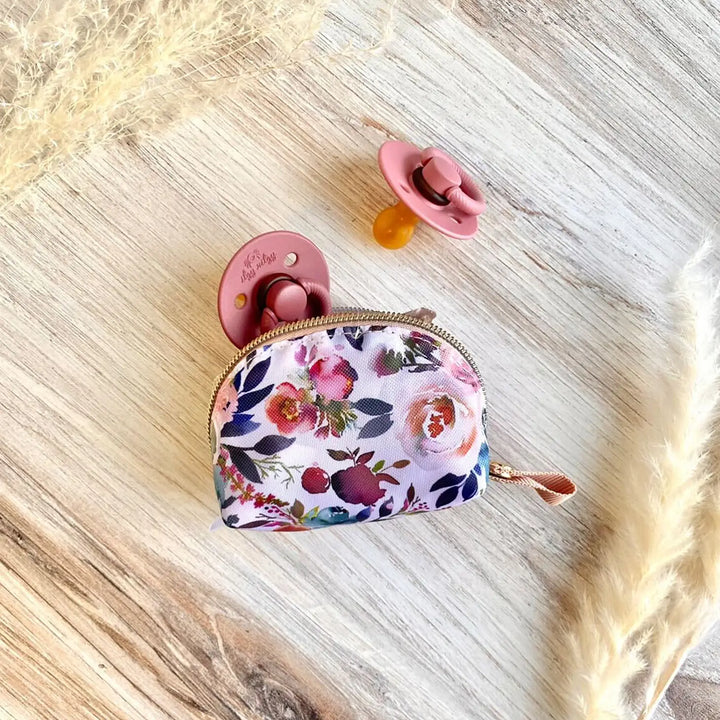 Itzy Ritzy Pacifier Pouch in Blush holding two rubber pacifiers